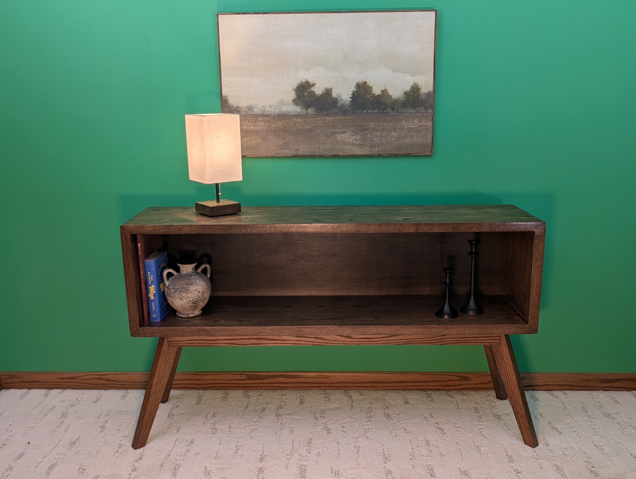 Solid oak console staged with a lamp, books, pottery and candlesticks