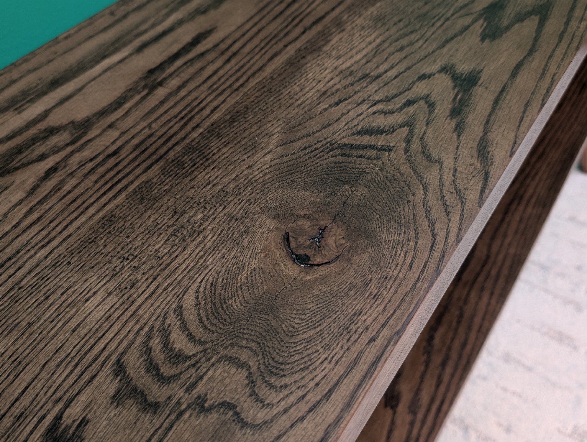 Close view of a preserved knot and radiating grain on the oak top