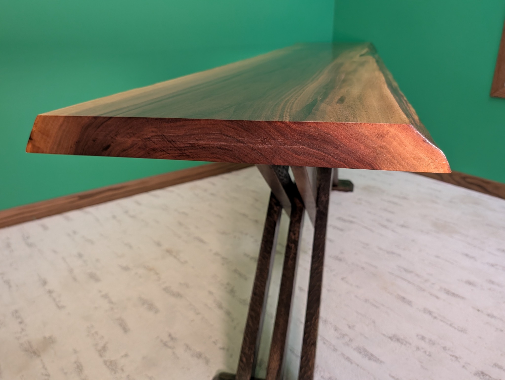 End-grain profile of the black walnut slab above the geometric oak base