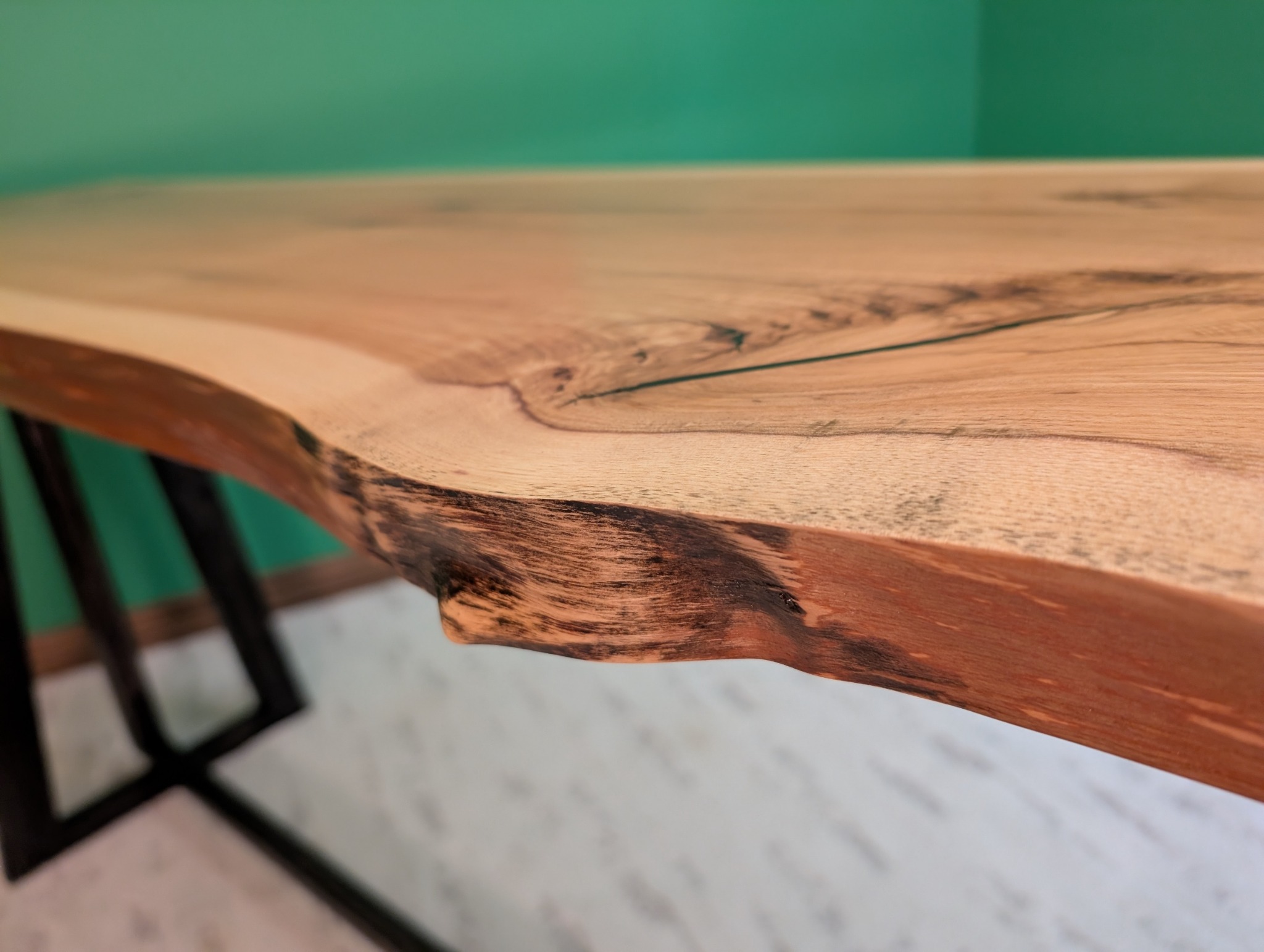 Close view of the hickory slab's natural edge and dark grain line